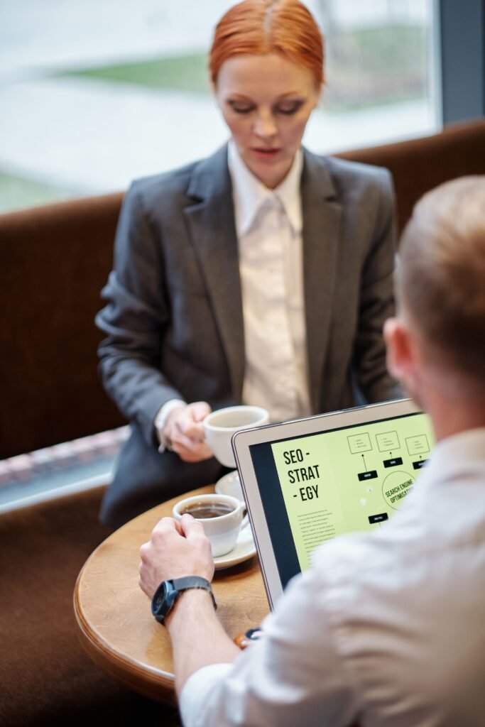 Professional meeting in a café with a laptop showcasing an SEO strategy. Ideal for business concepts.